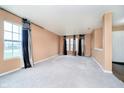 Spacious living room boasts neutral carpeting, large windows, and stylish window treatments, creating a bright and airy atmosphere at 2885 Holiday Way, Greenwood, IN 46143