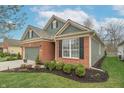 A detailed view of the home's side showcasing the brickwork, landscaping, and a two-car garage at 3444 Windy Knoll Ln, Carmel, IN 46074