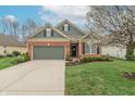 Attractive home with brick facade, neat landscaping, and a convenient two-car garage, offering curb appeal at 3444 Windy Knoll Ln, Carmel, IN 46074