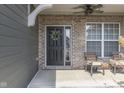 Charming front porch with brick accents, a wreath, and stylish seating area at 4182 Backstretch Ln, Bargersville, IN 46106