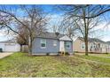 Single-story house with gray siding and a neat front yard, offering a cozy curb appeal and a detached garage at 5309 E 19Th Pl, Indianapolis, IN 46218