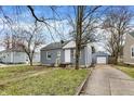 View of a one-story home and detached garage with gray siding, white trim, and inviting curb appeal at 5309 E 19Th Pl, Indianapolis, IN 46218
