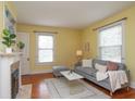Cozy living room featuring a decorative fireplace, hardwood floors, and ample natural light at 5915 Lowell Ave, Indianapolis, IN 46219