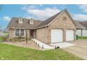 Brick home with a two-car garage, front yard featuring manicured landscaping, and a welcoming walkway at 607 N White Ash N Ct, Mooresville, IN 46158