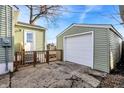 Detached one-car garage with a freshly painted white door and light green siding to match the house at 621 Melvenia St, Indianapolis, IN 46219