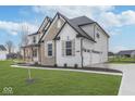 Attractive two-story home with an attached three-car garage, manicured lawn, and stone details at 6609 N Dogwood Dr, McCordsville, IN 46055