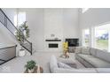 Living room with soaring ceilings, black and metal staircase, and modern fireplace at 6609 N Dogwood Dr, McCordsville, IN 46055
