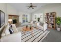 Bright living room with stone fireplace, ceiling fan, neutral colored furniture, and access to sunroom at 7228 Muirfield Pl, Indianapolis, IN 46237