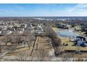 Beautiful aerial view of land lot featuring frozen pond, mature trees and surrounding neighborhood at 10990 Brooks School Rd, Fishers, IN 46037