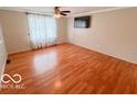 Spacious bedroom features hardwood floors, ceiling fan and light fixture, and a large window with coverings at 1402 Hornaday Rd, Brownsburg, IN 46112