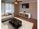 Living room with wood floors, couch, modern coffee table, television, and neutral colored walls at 1402 Hornaday Rd, Brownsburg, IN 46112