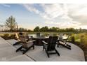 Inviting fire pit area with Adirondack chairs overlooking a scenic pond at 1463 Crosstie Cir, Westfield, IN 46074
