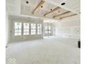 Bright, open living space with large windows and decorative ceiling beams, awaiting final touches at 1463 Crosstie Cir, Westfield, IN 46074