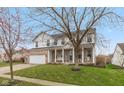 Charming two-story home with brick and vinyl exterior, covered porch, green lawn, and mature tree at 15885 Symphony Blvd, Noblesville, IN 46060