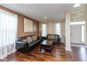 Comfortable living room with hardwood floors, two black couches, and two large windows with curtains at 15885 Symphony Blvd, Noblesville, IN 46060