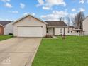 Charming one-story home featuring an attached garage and well-maintained front yard at 1683 Sweetwater Ln, Greenfield, IN 46140