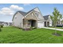 Wide shot of the gray home from across the lawn, showing architectural details and landscaping at 16955 Cole Evans Dr, Noblesville, IN 46060
