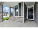 Inviting porch showcasing stone accents, black shutters, and a stylish front door at 16955 Cole Evans Dr, Noblesville, IN 46060