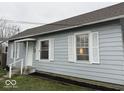 Charming bungalow-style home featuring light blue siding, white trim, and an attractive lawn at 2406 E 10Th St, Anderson, IN 46012