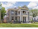 Elegant two-story home featuring grand columns and a manicured lawn, blending classic architecture with modern landscaping at 3447 Washington Blvd, Indianapolis, IN 46205