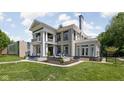 A manicured lawn frames a beautiful home, showcasing elegant columns, lush landscaping and a serene outdoor space at 3447 Washington Blvd, Indianapolis, IN 46205