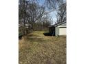 A backyard view showing a detached garage, lawn, and some trees at 3521 N Rural St, Indianapolis, IN 46218