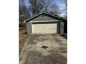 A detached, single-car garage with a large overhead door is located at the end of a long concrete driveway at 3521 N Rural St, Indianapolis, IN 46218