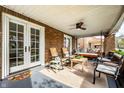 Covered front porch featuring comfortable seating, a ceiling fan, and brick pillars at 3652 N Delaware St, Indianapolis, IN 46205