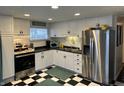 Modern kitchen with stainless steel appliances, ample cabinet space, and a stylish black and white checkered floor at 428 E Trevor St, Brownsburg, IN 46112