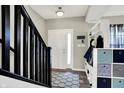 Inviting entryway featuring a staircase with black railings and a built-in storage bench at 4345 Maize Ln, Whitestown, IN 46075