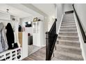 Open foyer view with a carpeted staircase, coat storage, and access to the living area at 4345 Maize Ln, Whitestown, IN 46075