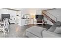 Open-concept space featuring a living area with a gray sofa, a dining area, and a kitchen with modern appliances at 4814 Lynton Ct, Indianapolis, IN 46254