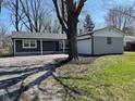 Exterior view of house with attached garage and yard with mature trees at 5105 Manning Rd, Indianapolis, IN 46228
