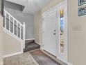 Inviting foyer with tile flooring, a staircase, and a front door with glass inserts at 5524 Cherry Blossom Ct, Indianapolis, IN 46237