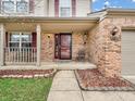 Close-up of the brick front elevation with an inviting covered porch and decorative landscaping at 5524 Cherry Blossom Ct, Indianapolis, IN 46237