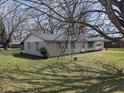 Side view of the brick home with a well-maintained lawn and mature trees at 5961 N 200 W, Columbus, IN 47201