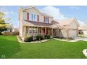 Beautifully landscaped front yard with a lush green lawn and established landscaping at 6134 Chadsworth Way, Lawrence, IN 46236