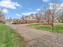 Spacious home exterior with a large driveway, expansive yard, and a detached garage at 6347 St Joe Dr, Indianapolis, IN 46217