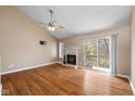 Spacious living room featuring a fireplace, vaulted ceilings, hardwood floors, and a sliding glass door to a balcony at 652 Blossom Dr, Avon, IN 46123
