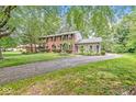 Traditional two-story brick home featuring mature trees and long driveway at 7138 Avalon Trail Ct, Indianapolis, IN 46250