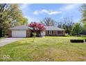 Traditional brick home with an attached garage, mature trees, and a green lawn in a well-maintained neighborhood at 7263 Hidden Valley Dr, Plainfield, IN 46168