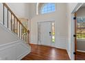 Bright foyer featuring hardwood floors, a staircase, and a large window above the front door at 8259 Plumwood Ln, Indianapolis, IN 46256