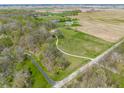 An aerial view displaying the home with a long drive, nestled in a setting of trees and cultivated fields at 8654 N Baltimore Rd, Monrovia, IN 46157