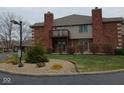 Attractive home featuring a brick facade, second story balcony, and manicured landscaping at 8955 Stonegate Rd # A, Indianapolis, IN 46227