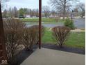 Exterior view overlooking well-maintained landscaping and a tranquil pond at 8955 Stonegate Rd # A, Indianapolis, IN 46227