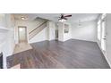 Spacious living room showcasing beautiful dark wood flooring, bright natural light, and staircase at 1045 Evening Shade Cir, Beech Grove, IN 46107