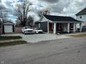 A cute single-story house with a front porch, side parking, and a well-maintained yard at 109 S County Line Rd, , IN 47272