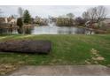 Backyard view showcasing a serene pond with a fountain surrounded by lush greenery at 143 Tracy Ridge Blvd, Whiteland, IN 46184