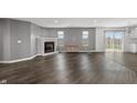 Spacious living room with dark wood floors, a fireplace, and large windows at 153 Terrace Ct, Franklin, IN 46131