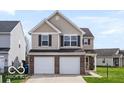 View of the home's front exterior, including a two-car garage and a well-kept lawn at 15444 Old Pond Cir, Noblesville, IN 46060
